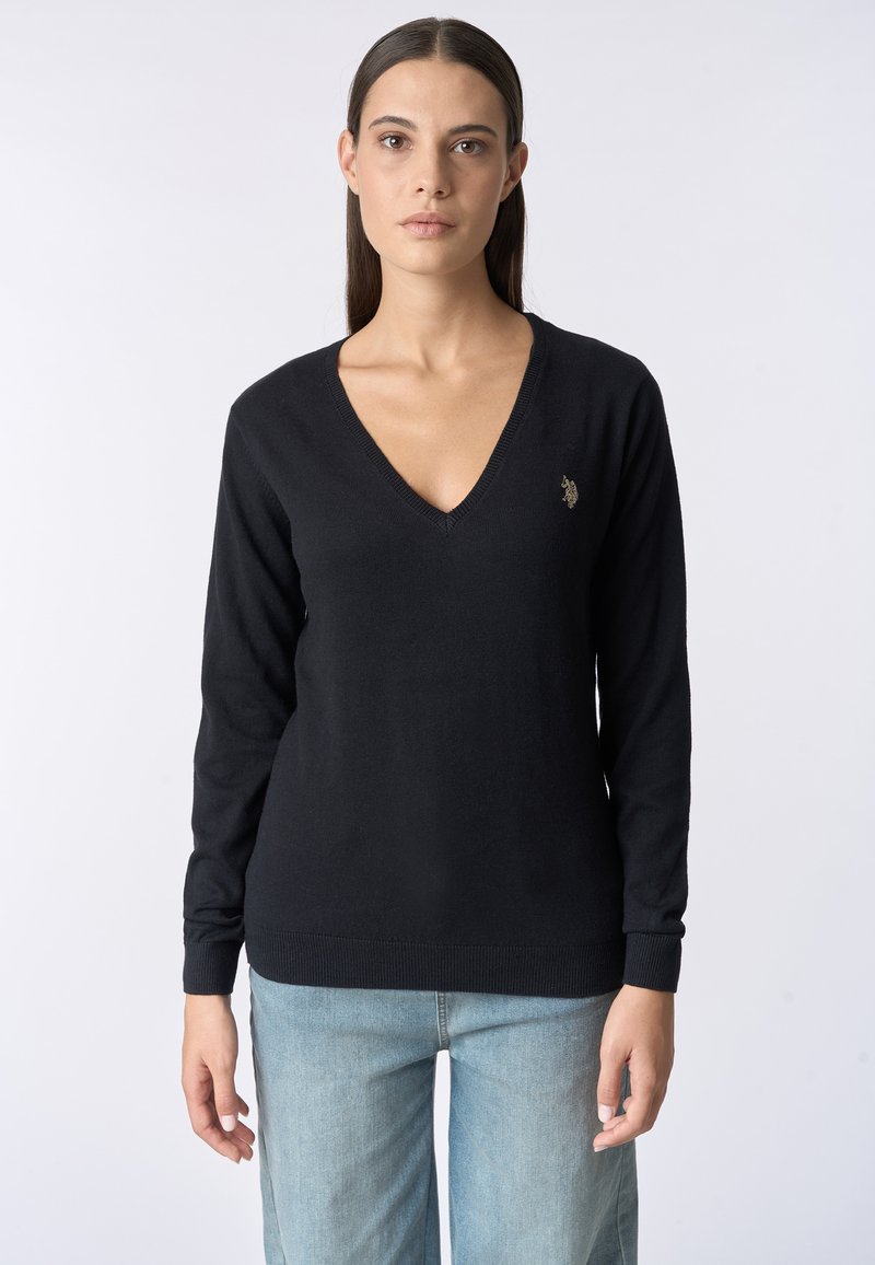 Maglione nero aV con maniche lunghe, realizzato in materiale morbido. Presenta un piccolo logo ricamato sul petto sinistro, polsini e orlo a costine.