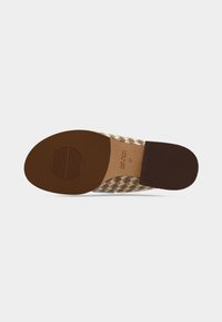 Chaussure à enfiler tissée avec une semelle en caoutchouc marron, un motif en zigzag aux nuances de beige, marron et bleu, et un design plat.