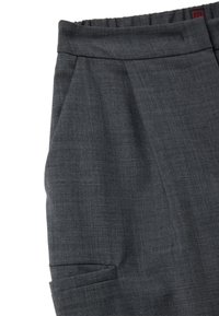 Pantaloni grigi su misura realizzati in tessuto leggero. Presentano una vita piatta, pinces e una tasca laterale per maggiore funzionalità.