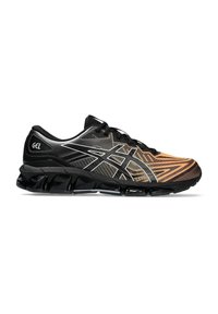 Des chaussures de sport noires et orange avec une tige en maille texturée, des accents argentés, une semelle rembourrée et un motif ondulédistinctif.