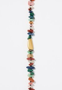 Multicolored bead necklace featuring irregular-shaped stones in shades of green, red, pink, and gold, strung on black threading.
