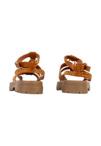 Sandales à bride cheville en daim marron avec brides cloutées et semelles épaisses en caoutchouc, vues de dos sur fond blanc.