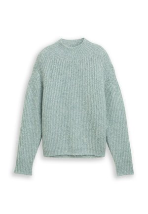 Šviesiai žalia grublėta megztinė su aukštu kaklu ir ilgomis rankovėmis, pasižyminti tekstūruotu mezgimu ir trumpu apvadu.