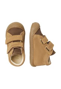 Scarpe per bambini in suede e pelle marrone con due cinturini in velcro, punta rotonda e suola in gomma testurizzata. Disponibili in una combinazione di colori beige e marrone scuro.