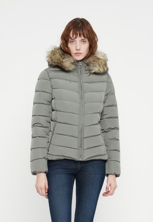Puffer jacket in light gray with a faux fur hood, ribbed texture, front zip closure, and side pockets. Elegant horizontal stitching design.