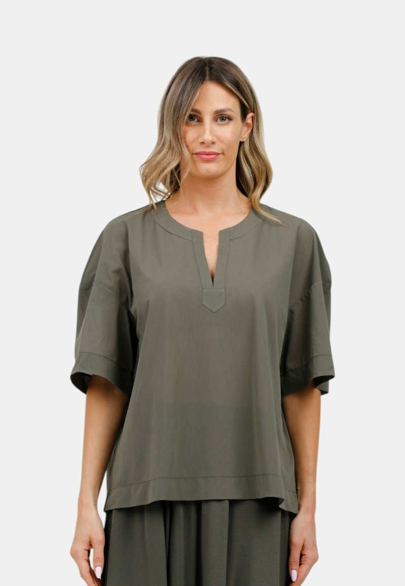 Blusa verde oliva a maniche corte con scollatura a V e una leggera lucentezza. Vestibilità rilassata, texture liscia e orlo dritto. Nessun motivo o dettaglio visibile.