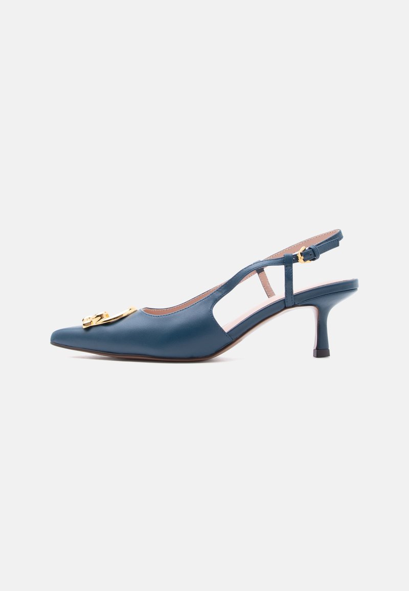 Escarpin slingback en cuir bleu avec petit talon, bout pointu et détail de boucle dorée sur le côté, isolé sur fond clair.