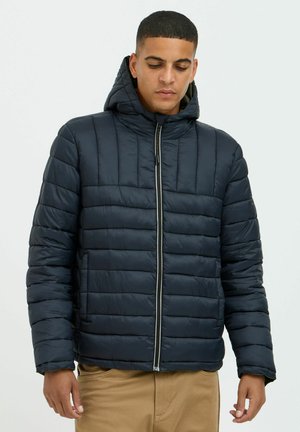 Navy puffer jacket with a hood, featuring horizontal quilting, a front zipper, and soft, shiny fabric. Includes pockets on the sides.