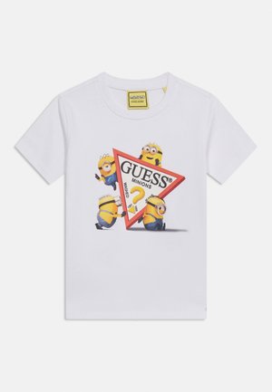 Bijela majica kratkih rukava s četiri Miniona koji drže crveni trokutasti logo s natpisom "GUESS Minions" u sredini.