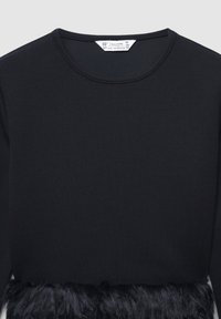 Maglietta nera a maniche lunghe con scollatura rotonda e un accento in pelliccia sintetica all'orlo. Tessuto liscio con un dettaglio inferiore soffice e texturizzato.