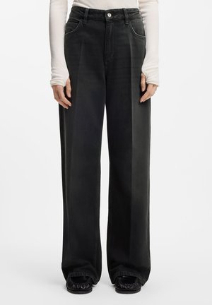 Wide-leg, black denim pants with a high waist, featuring front pockets and a silver button closure. Smooth texture and minimal stitching details.