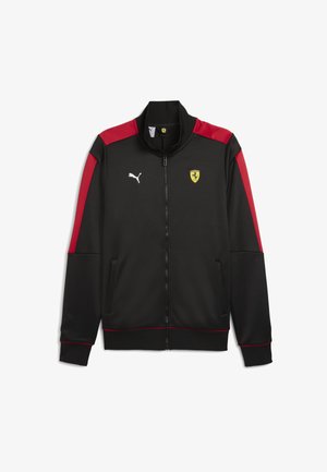 Zwarte sportjack met rode accenten, full zip, hoge kraag, met een logo op de borst en een wit merkembleem op de schouder. Zacht materiaal.