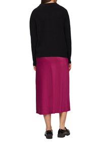 Schwarzer gerippter Pullover, rosa Satin-Midikleid, glatte Textur, leicht ausgestellt am Saum, kombiniert mit schwarzem Lacklederschuhen.