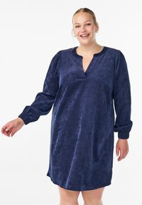 Námořnická modrá sametová šaty s V-výstřihem, nabíranými rukávy a elastickými manžetami; měkká textura; délka ke kolenům, představující jednoduchý design.