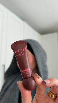 Brun NYX Smushy Matte Lip Balm i klemmetube med afrundet ende, med lyserød tekst, 8 mL størrelse. Baggrunden er sløret.
