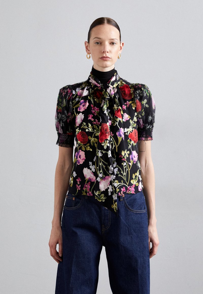Floral blouse with puff sleeves, black background, vibrant red, pink, and purple flowers, tied neck detail, lace accents on sleeves.