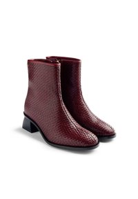 Botas de tobillo trenzadas burdeos con un acabado texturizado, un tacón bajo y un cierre de cremallera lateral. Forro interior suave.