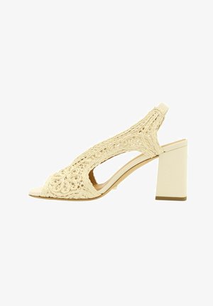 Sandalo slingback beige con punta aperta, tomaia intrecciata e tacco a blocco, vista laterale su sfondo bianco.