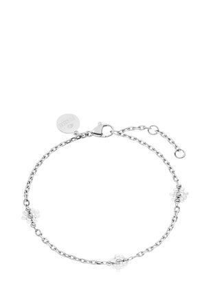 Zarter Silberkettenarmband mit kleinen blumenförmigen Perlen entlang der Kette und einem runden Markenzeichen nahe dem Verschluss.