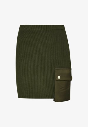 Gonna mini in maglia di colore verde scuro con vita aderente, dotata di tasca laterale e dettaglio con bottone a pressione. Tessuto a coste testurizzato.