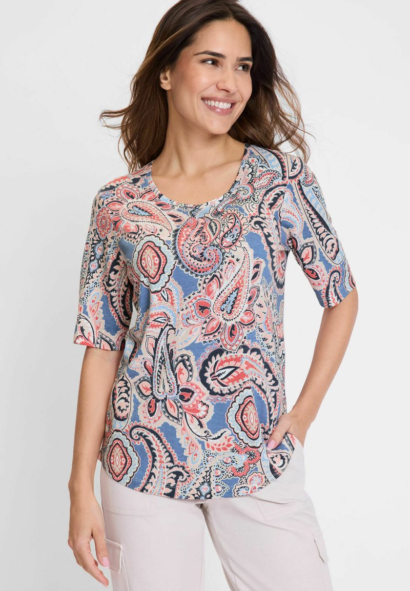 Short-sleeve blouse in blue with a colorful paisley pattern. Features a rounded neckline and soft fabric with visible stitching details.