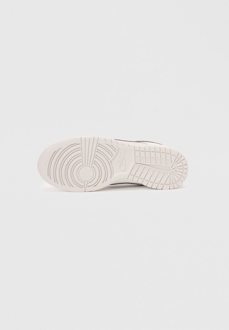 Nike sneaker zool in wit rubber met een circulair profiel en gegraveerde lijnen, met minimale zichtbare branding.