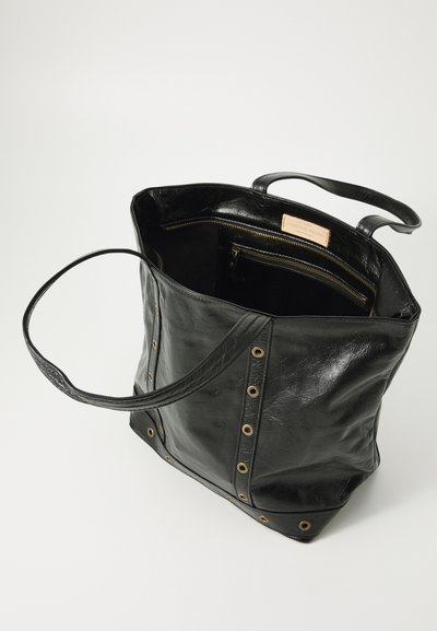 Sac fourre-tout en cuir noir avec double poignées, accents en œillets dorés et une poche zippée intérieure étiquetée Vanessa Bruno, avec un haut ouvert.