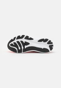 Semelle d'une chaussure de sport avec un motif de bande de roulement noir et blanc conçu pour l'adhérence et la durabilité.
