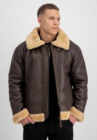 Chaqueta de cuero marrón con un suave cuello y puños de piel sintética beige, que cuenta con un cierre de cremallera y una superficie texturizada.