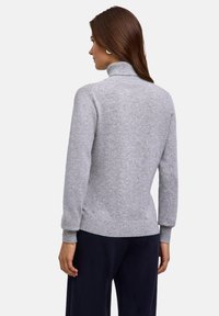 Maglione grigio lavorato a maglia con colletto alto e orlo e polsini a coste. Il design è aderente, con una texture liscia. Vista posteriore.