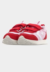 Κόκκινα και ροζ παπούτσια για νήπια με λευκή λεπτομέρεια σε σχήμα αστεριού, δύο κόκκινους ιμάντες με velcro, και υφασμένα λευκά πέλματα λοξά προς τα εμπρός.