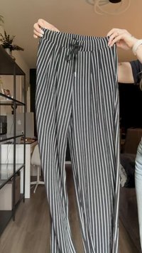 Svart-hvite stripete bukser med elastisk midje og justerbar snor. Lett stoff og rett ben-design.