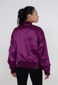 Satin bomberjack in diep paars, met een geribde kraag en manchetten, zijritsen en een losse pasvorm met verlaagde schouders.