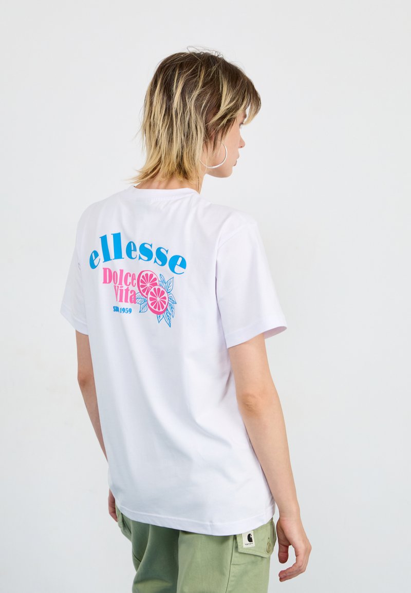 T-shirt en coton blanc avec un imprimé graphique coloré au dos avec "ellesse", "Dolce Vita" et des accents floraux. Manches courtes, coupe décontractée.