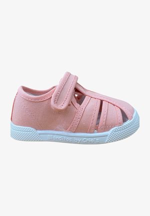 Zapato de tela rosa con punta cerrada y cortes laterales abiertos. Cuenta con una correa de velcro y una suela de goma blanca texturizada con marca.
