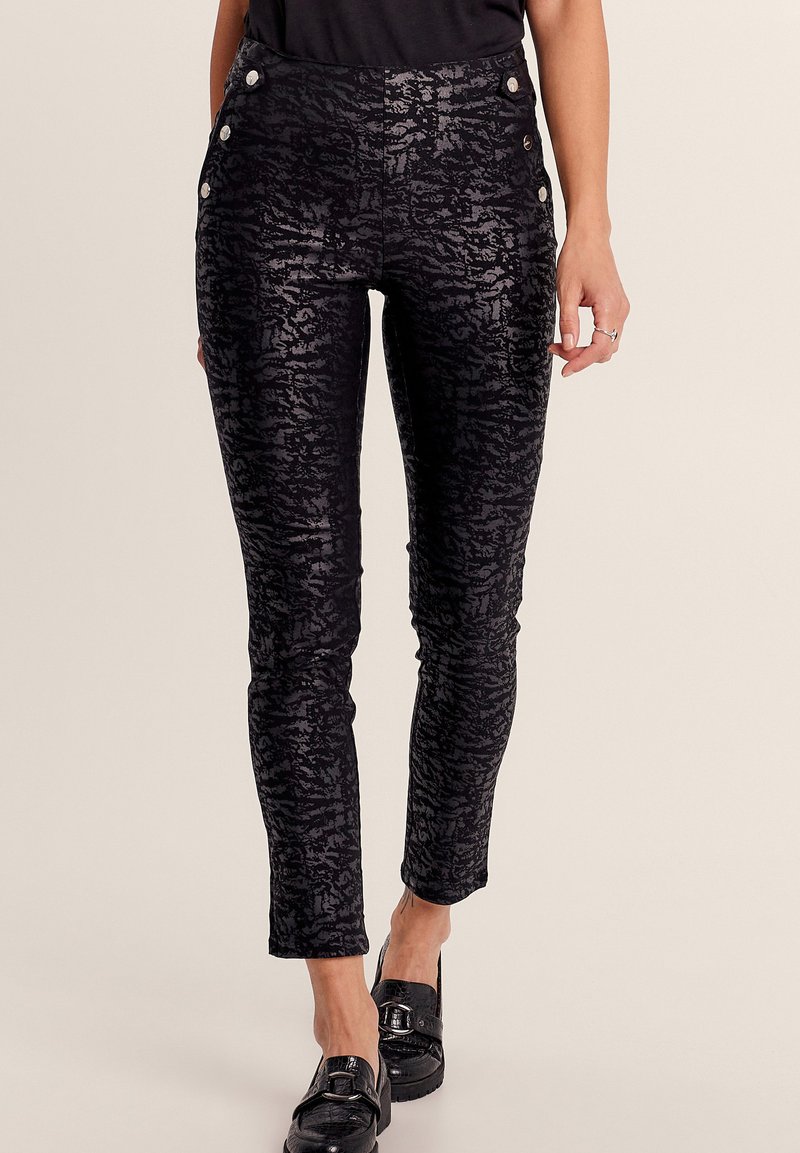 Pantaloni neri a fantasia con una vestibilità slim, realizzati in tessuto testurizzato, con bottoni decorativi sulla vita e un design a vita media.