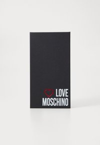 Juodas stačiakampis dėžutė su tekstūruota paviršiumi, priekinis logotipas baltos ir raudonos spalvos: širdies simbolis ir „LOVE MOSCHINO“ storu šriftu.