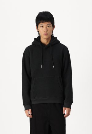 Melna flīsa kapuce ar kangaru kabatu, regulējama šņore uz kapuces un ribotām piedurknēm. Tekstūrēta auduma sastāvs nodrošina siltumu un komfortu.