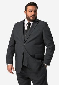 Un completo grigio scuro con giacca a due bottoni, revers a scorrimento e tasche laterali. Completato con una camicia bianca e una cravatta nera in tessuto textura.