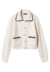 Bílý texturovaný kardigan s černým lemováním na límci a kapsách, zdobený zlatými knoflíky a krátkým střihem. Měkká pletená látka.