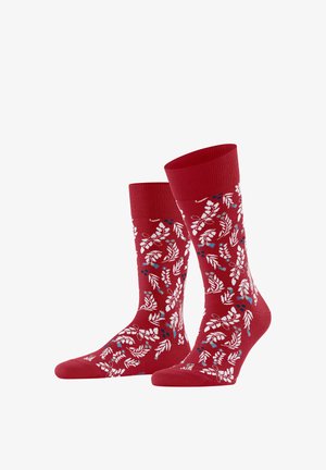 Calze da equipaggio rosse con motivi di foglie e bacche bianchi, blu e grigi, esposte in posizione verticale su uno sfondo bianco.