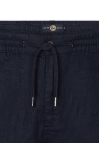 Pantaloni short in lino blu navale con vita elastica, chiusura con cordino e un'etichetta con il logo del brand sul davanti.