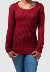 Burgundowy sweter robiony na drutach z textured wzorem, szerokim dekoltem oraz ściągaczami przy rękawach i u dołu. Długie rękawy i luźny fason dopełniają całość.