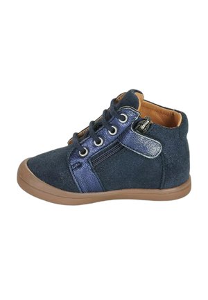 Kindersneaker van marineblauw suède met een beige zool, veters aan de voorkant, een rits aan de zijkant en een gevoerde kraag voor enkelondersteuning.