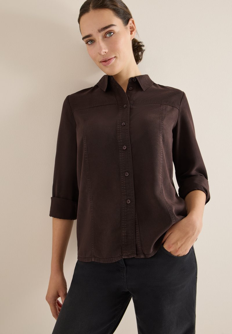 Dunkelbraunes Button-up-Hemd mit Kragen, hochgekrempelten Ärmeln und subtiler Glanz. Verfügt über Vorderknöpfe und Stickdetails.