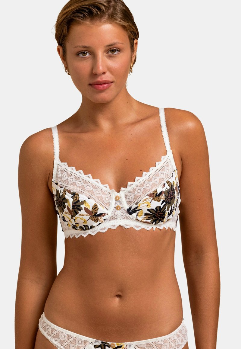 Ensemble de lingerie floral blanc avec des accents en dentelle, comprenant un bralette avec des bretelles ajustables, un détail de bouton et une bordure en zigzag.