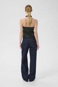 Svart lærstrapless topp med samlet tekstur, kombinert med mørkebl�å vide denimbukser. Begge plaggene har minimalistiske design detaljer.