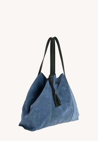 Sac fourre-tout en daim bleu doux avec des anses en cuir noir et un détail de pampille en cuir noir.