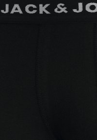 Black cotton underwear with a wide, elastic waistband featuring "JACK & JONES" in gray text. Smooth texture and fitted design.