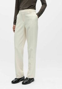 Kremfargede skreddersydde bukser med rette ben, som har sidelommer, glatt stofftekstur og høyt liv.